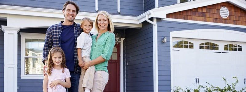 Happy family in front of their home with its new roof